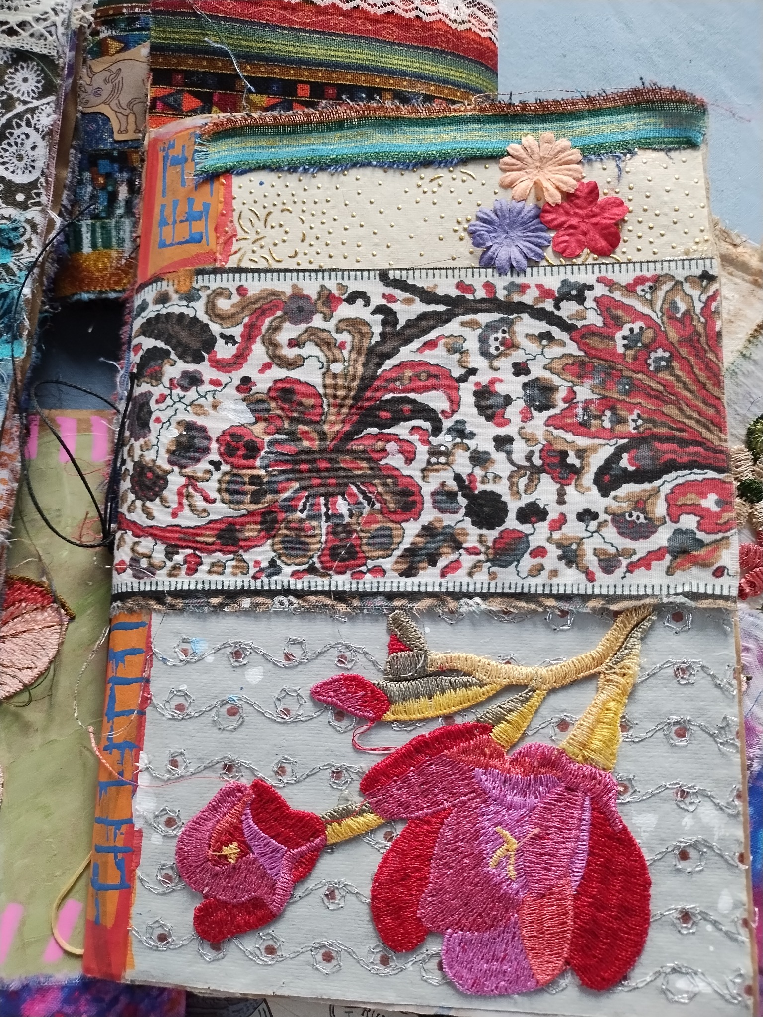 Handmade journal cover featuring floral embroidery, patterned fabrics, and lace details
